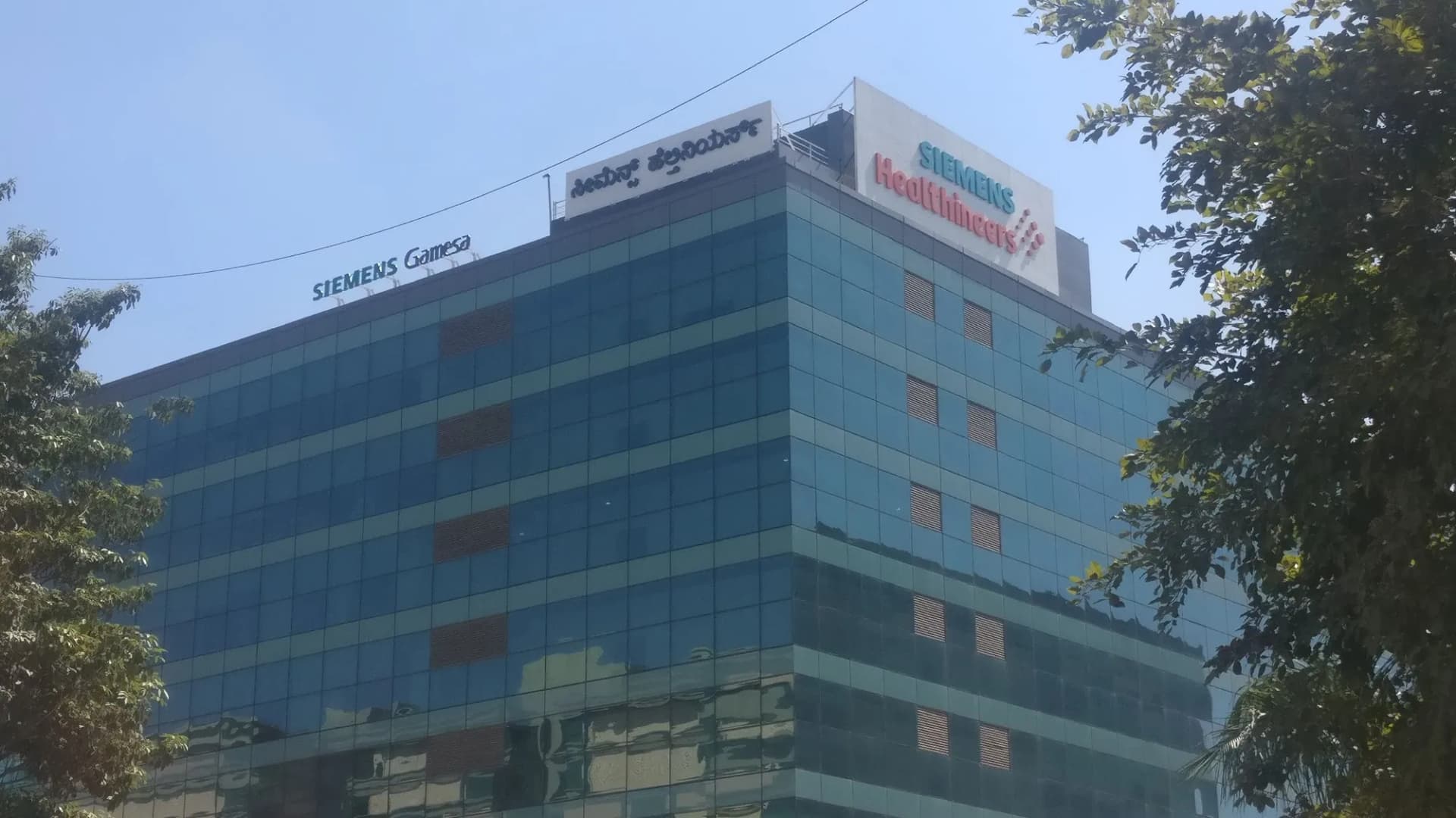Siemens Healthineers and Siemens Gamesa rooftop signs on a glass office tower