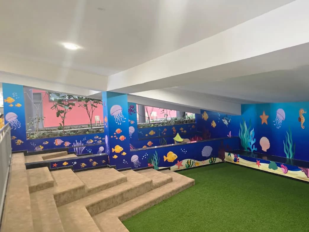 The same play area after: ocean graphics with fish, jellyfish, coral and starfish across the walls, pillars and planters
