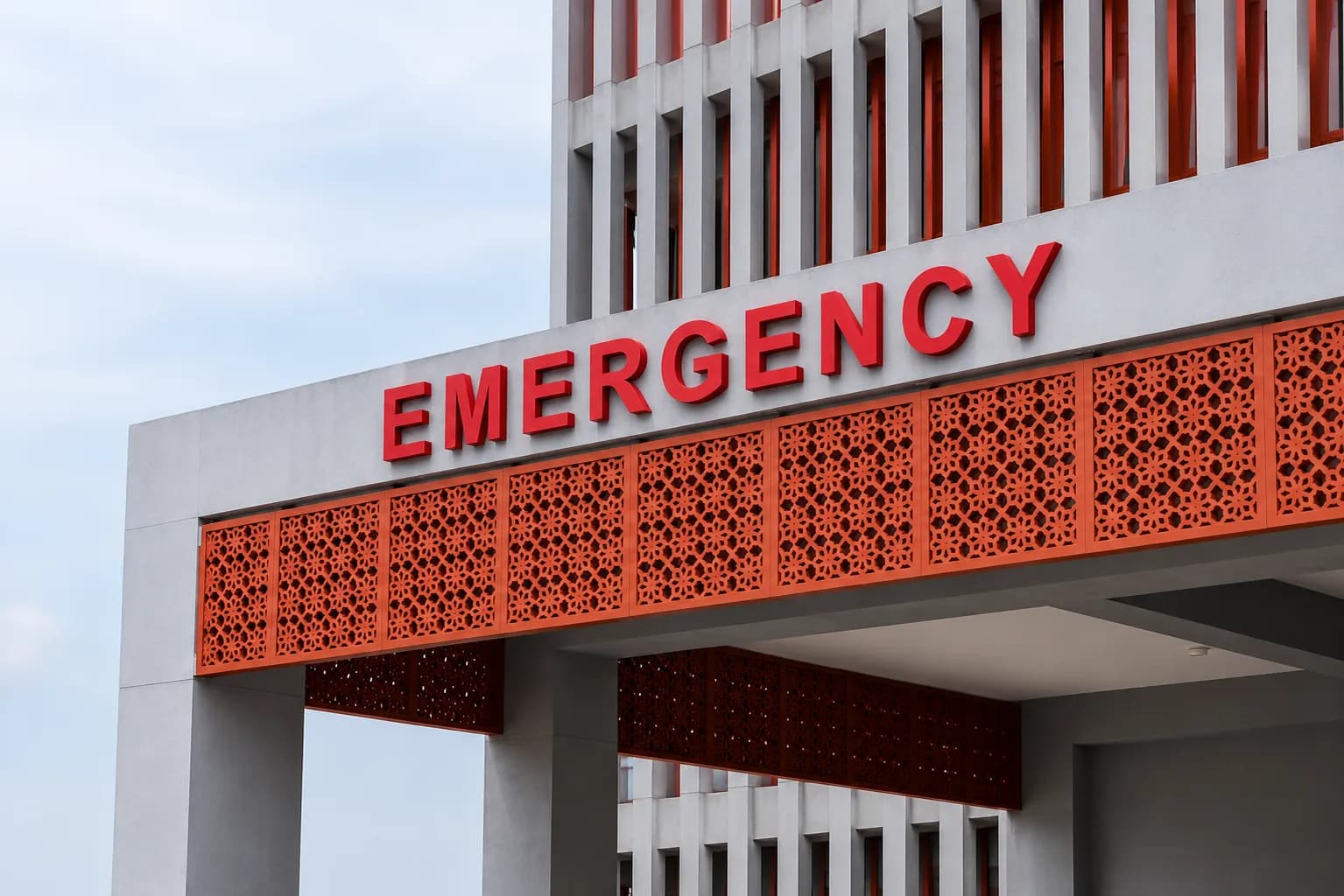 Red EMERGENCY letters on a hospital entrance canopy