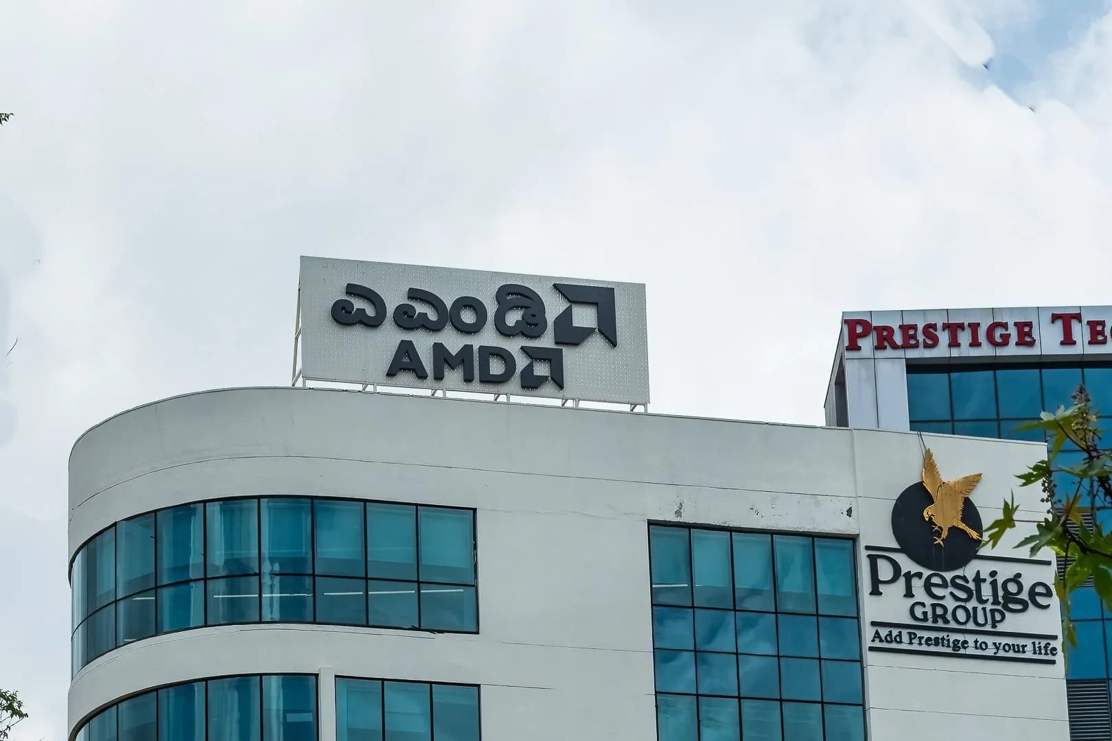 AMD rooftop sign on a curved glass office building