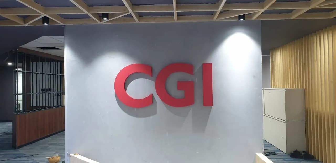 Red 3D CGI letters on a grey office wall