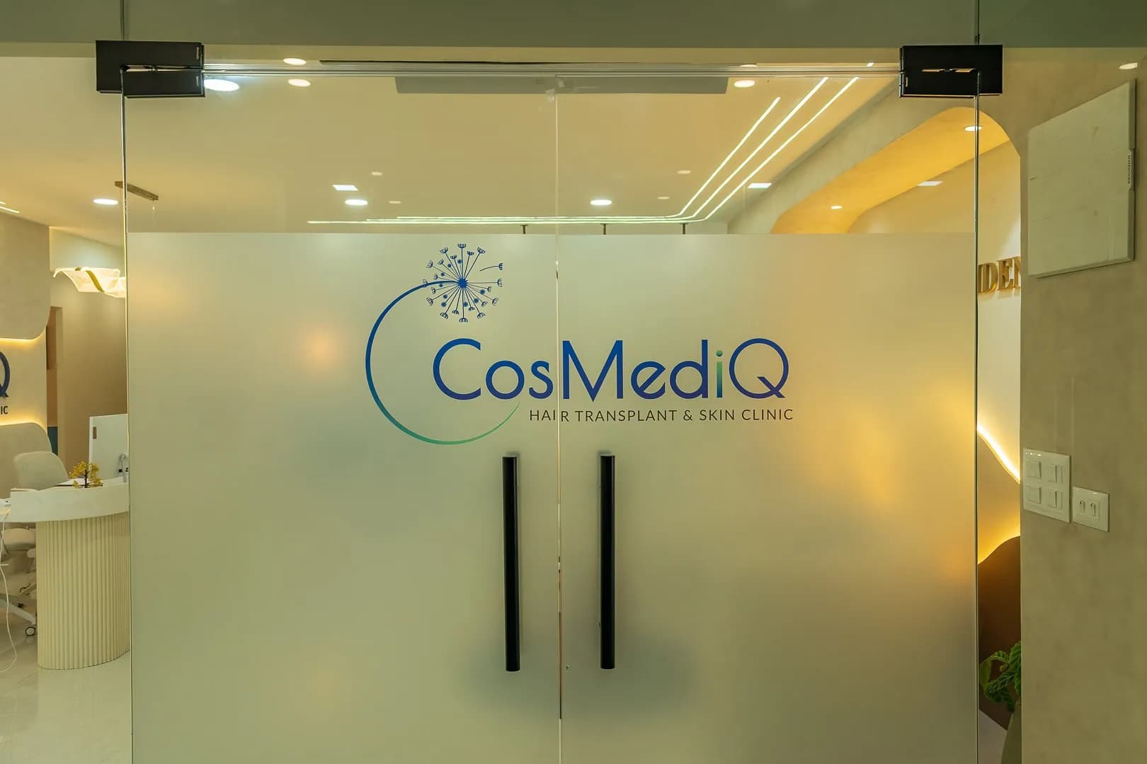 Frosted glass doors printed with the CosMediQ clinic logo