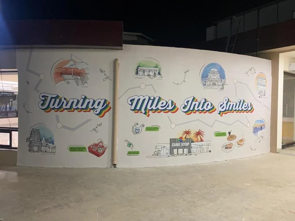 Illustrated landmark mural reading Turning Miles into Smiles on a curved wall