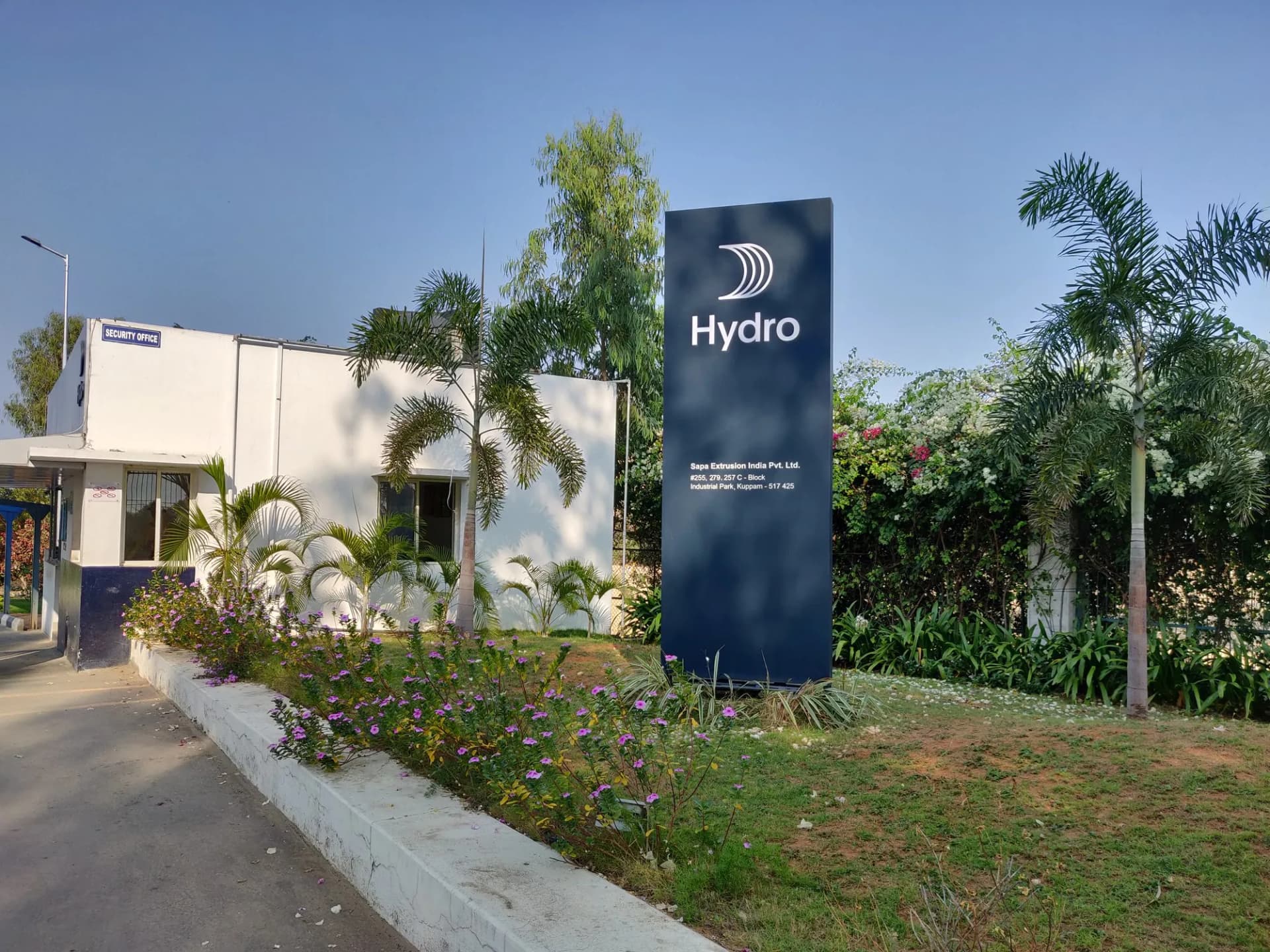 Navy Hydro totem beside a landscaped path at a factory entrance