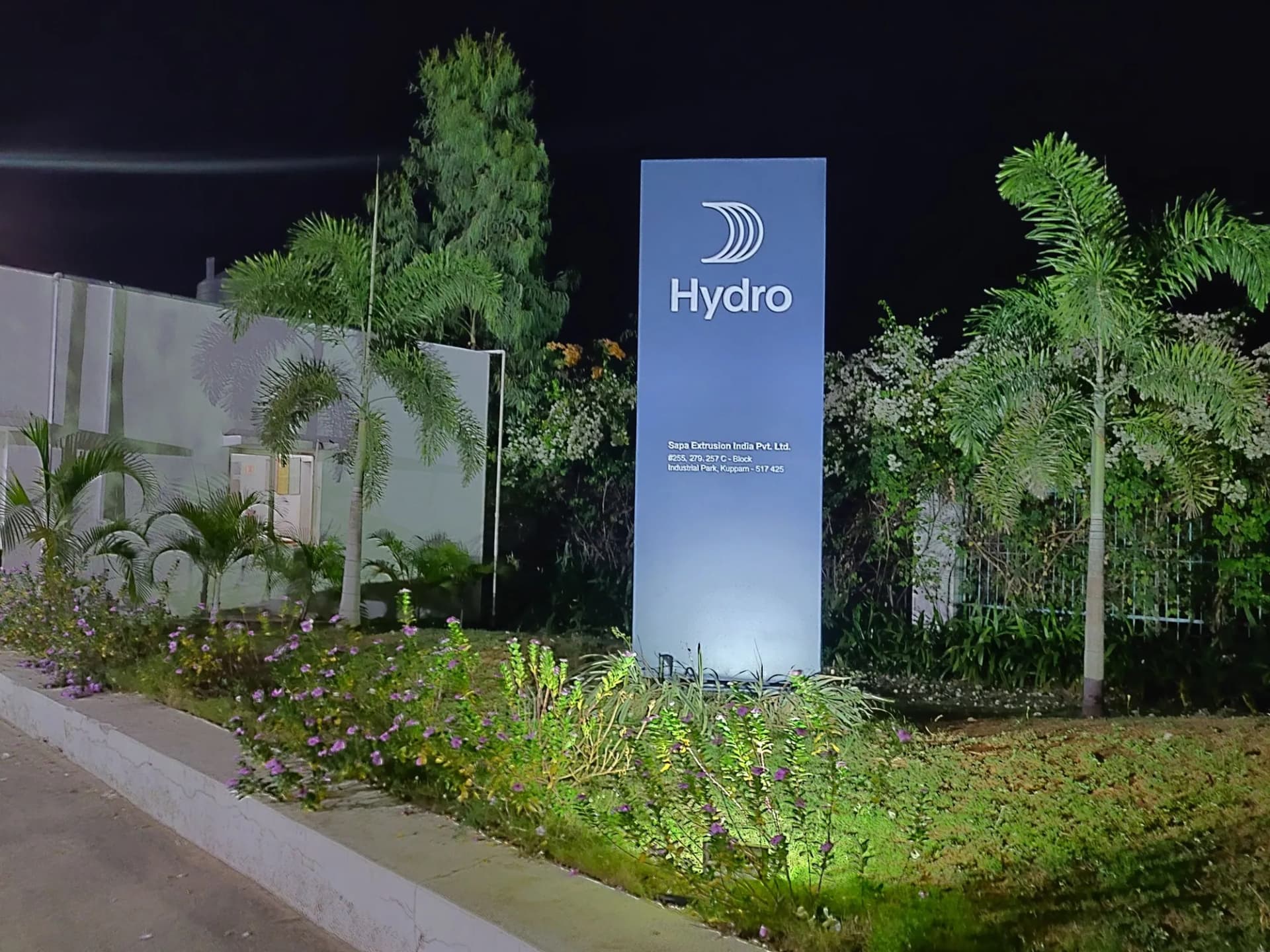 Hydro totem lit at night among landscaped plants