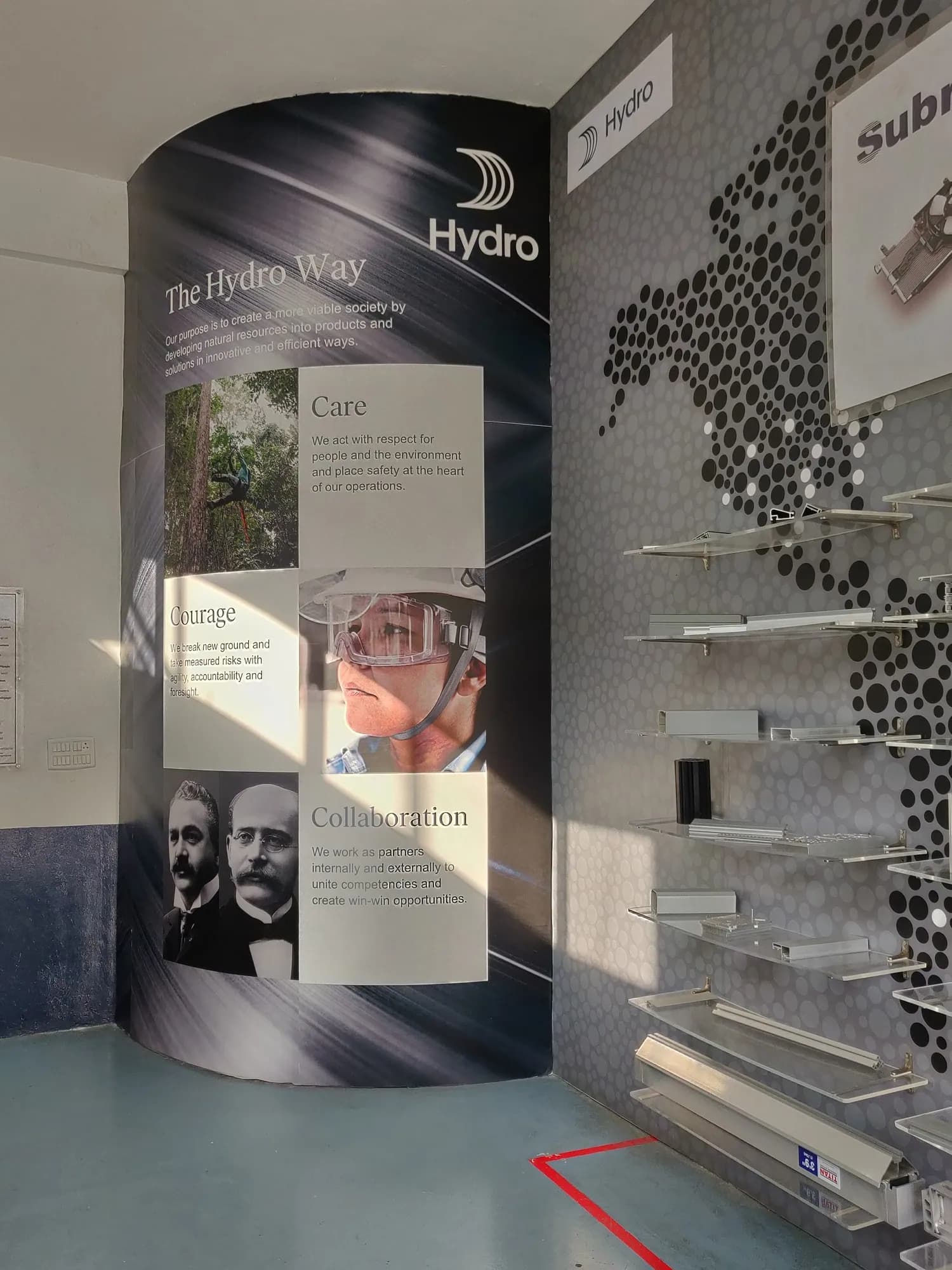 Curved Hydro Way wall graphic with the company values and photographs