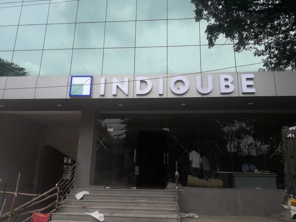 INDIQUBE steel letters on the fascia above a glass entrance