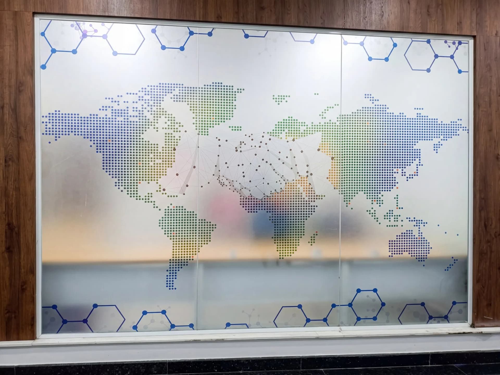 Frosted glass partition printed with a dotted world map in colour