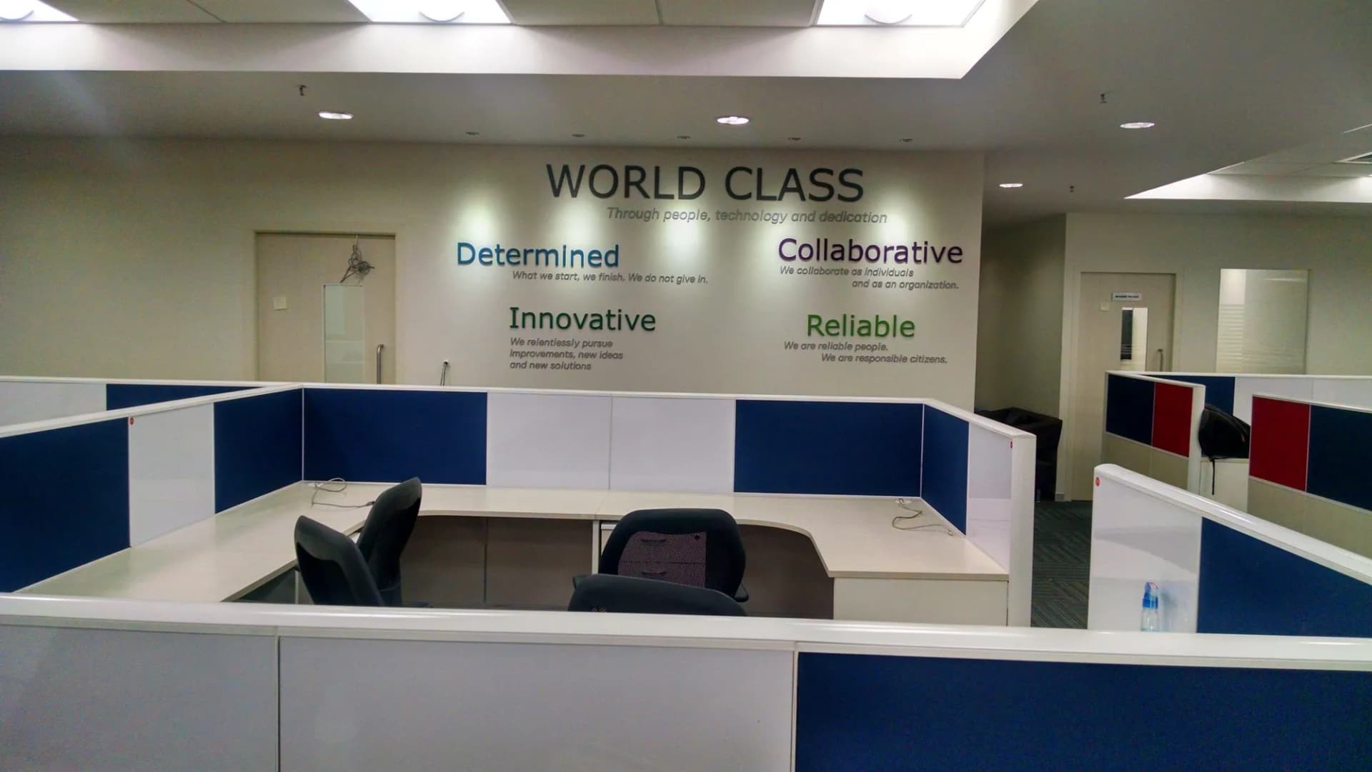 World Class values wall above the workstations: Determined, Collaborative, Innovative, Reliable