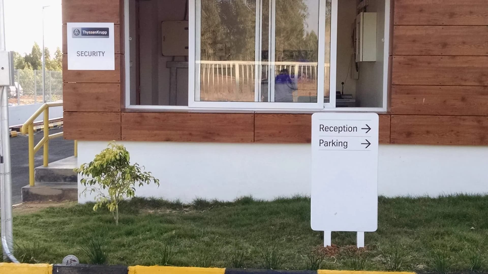 Reception and parking direction sign beside the ThyssenKrupp security cabin