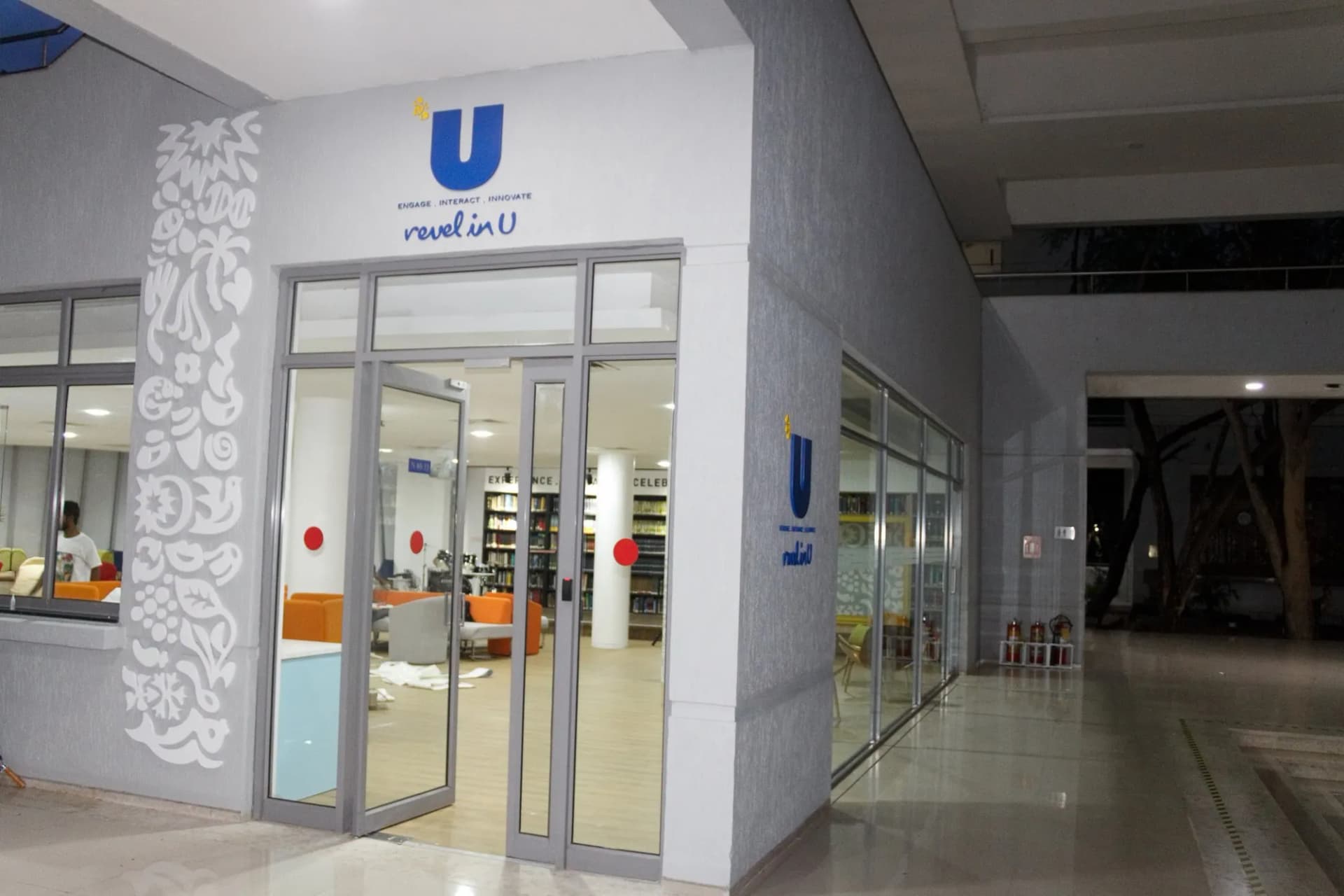 Unilever revel in U logo over a glass entrance with a white patterned wall graphic