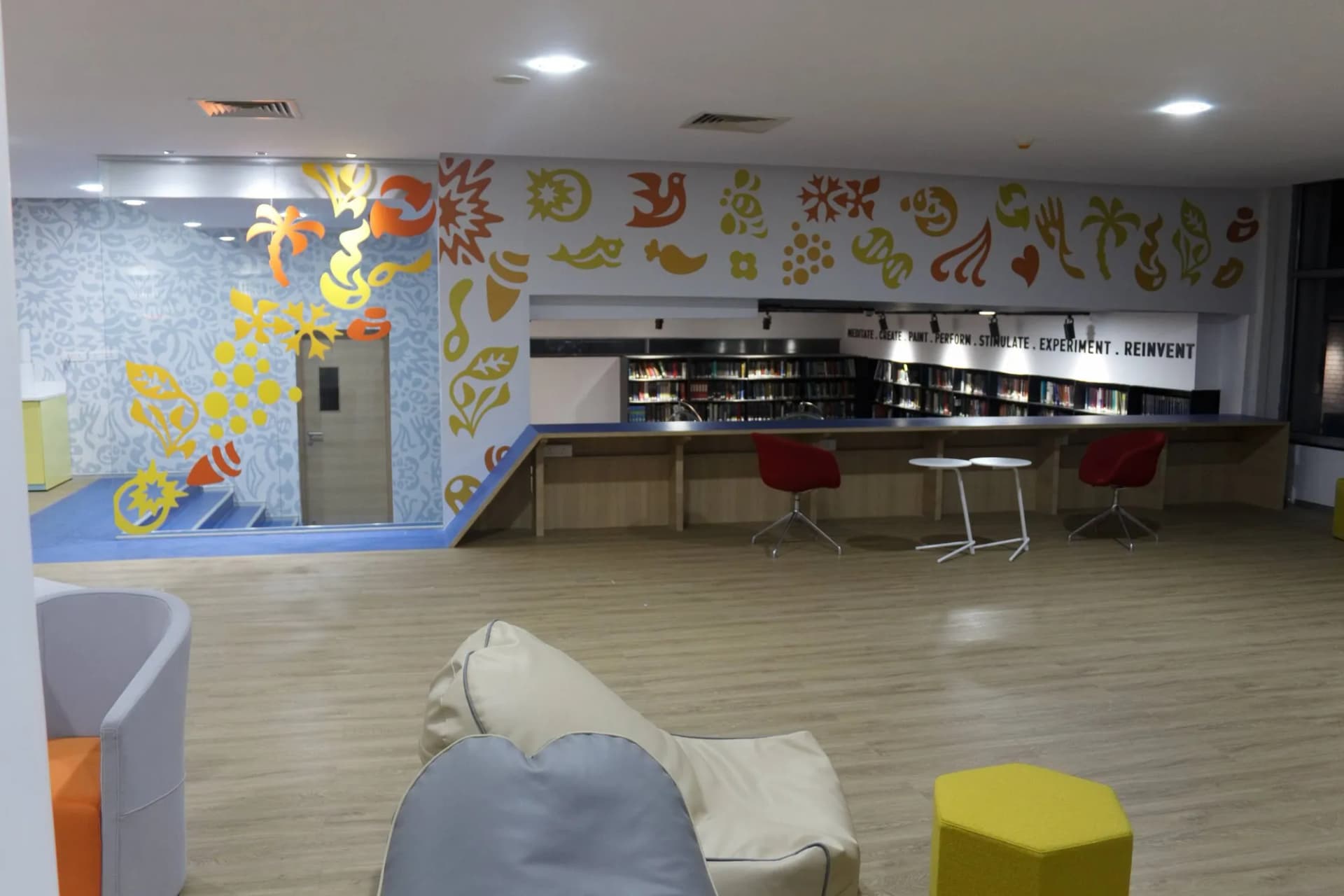 Long colourful icon-pattern wall graphic over the library and lounge at Unilever