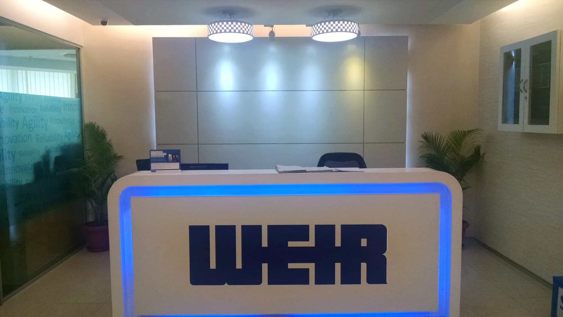 WEIR letters on a white reception desk with a blue lit edge