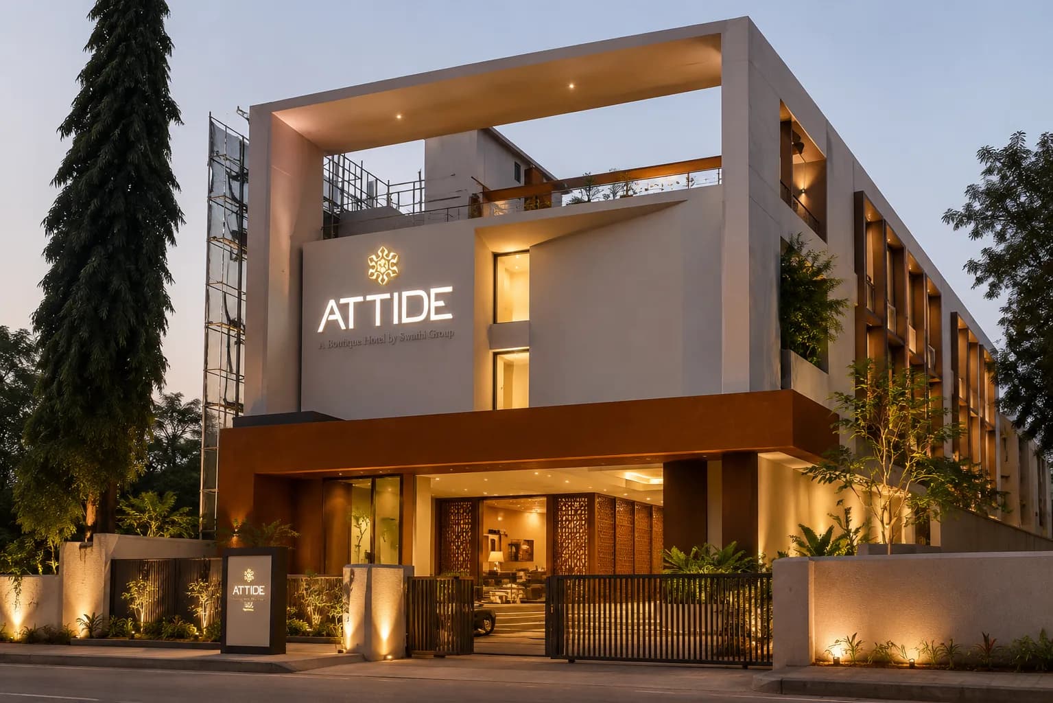 Attide hotel building with the lit logo sign at dusk